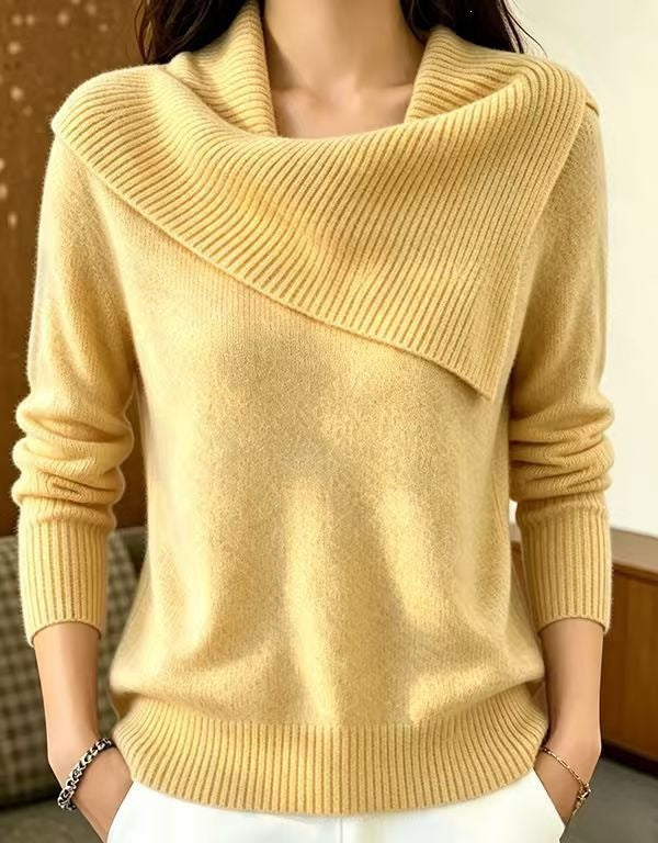 A woman wearing a pale yellow knit sweater with a wide draped cowl neckline and long sleeves, paired with white pants.