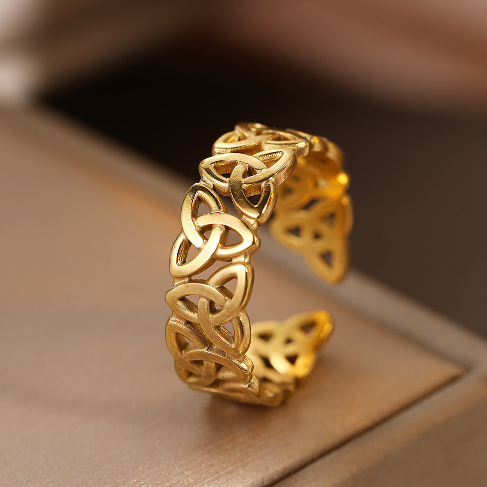 Gold Celtic knot ring on a brown surface
