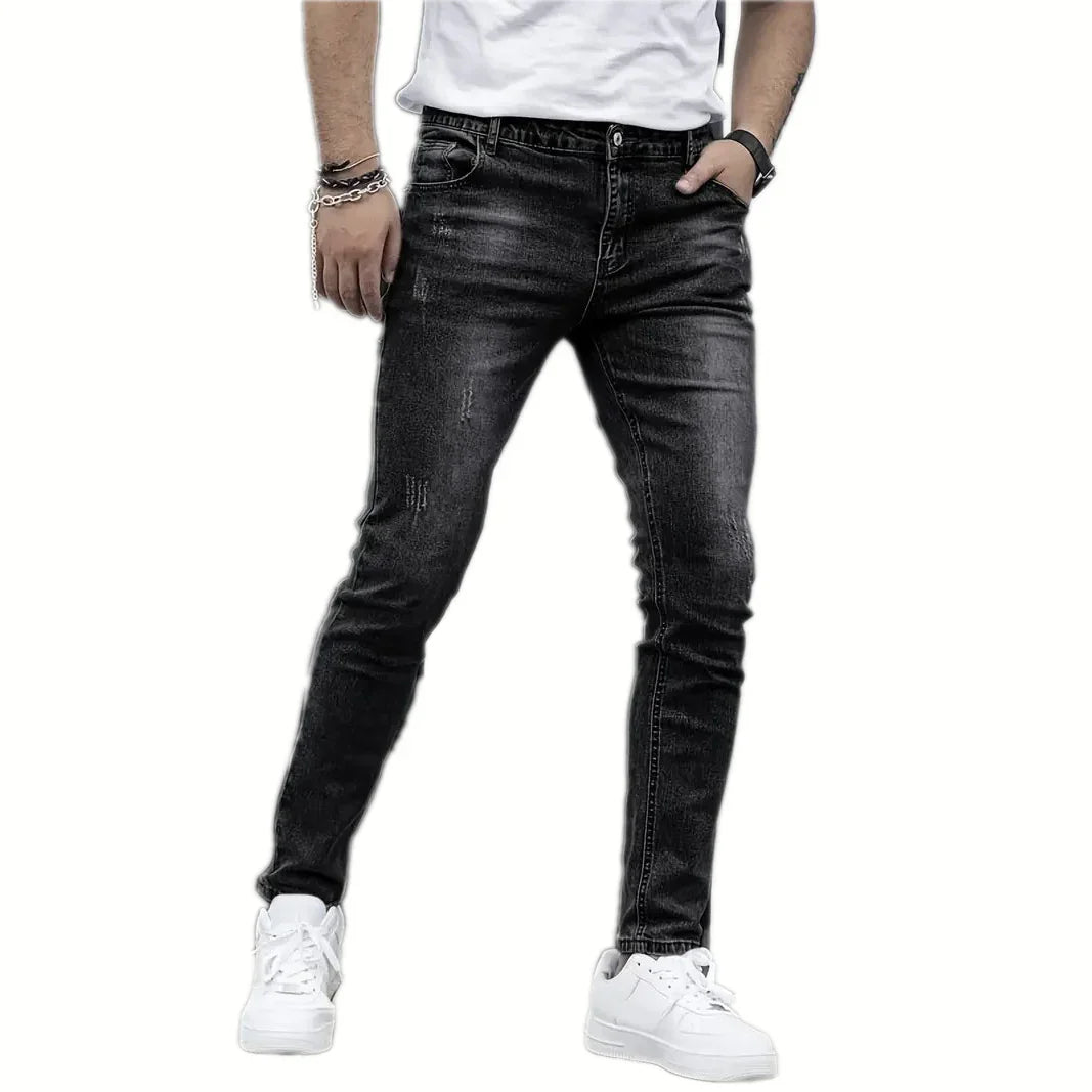 Person wearing black jeans and white sneakers on a white background
