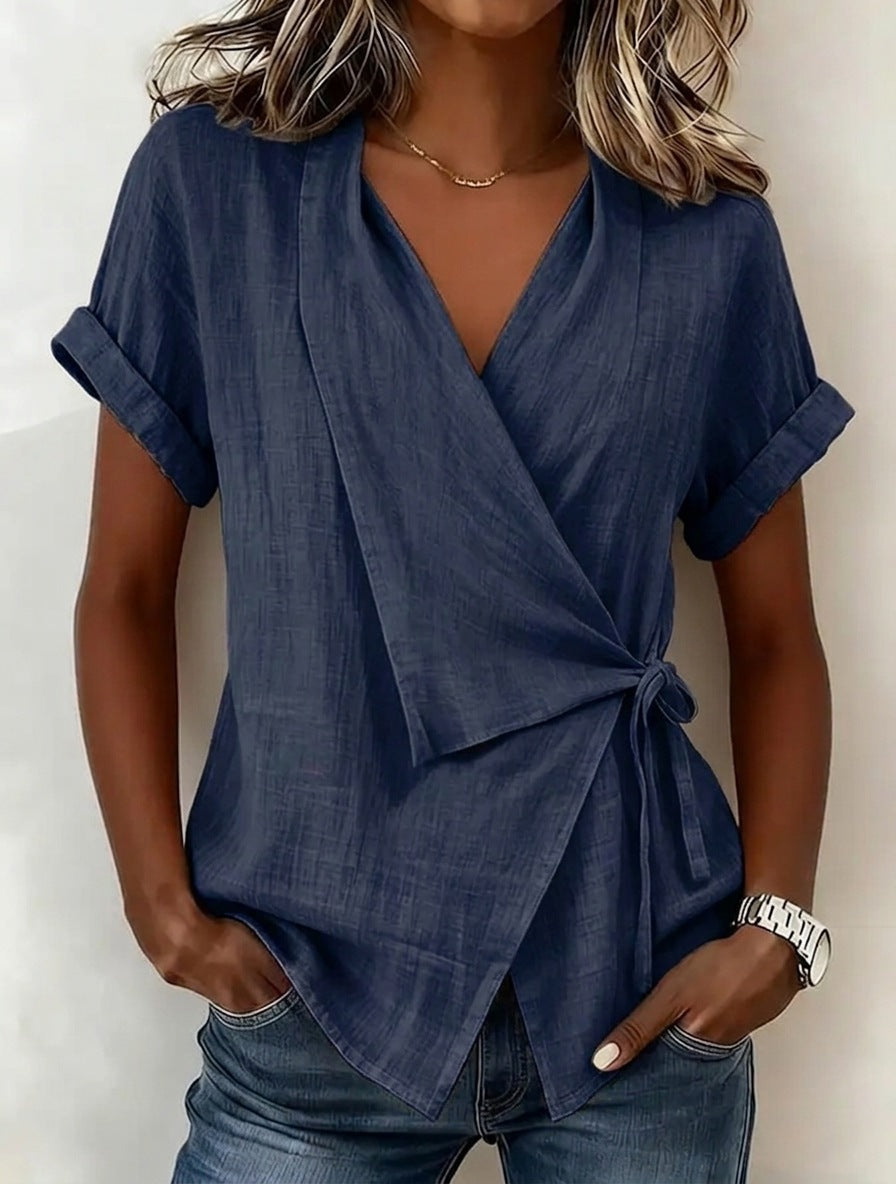 Woman wearing a blue wrap top with a plain background