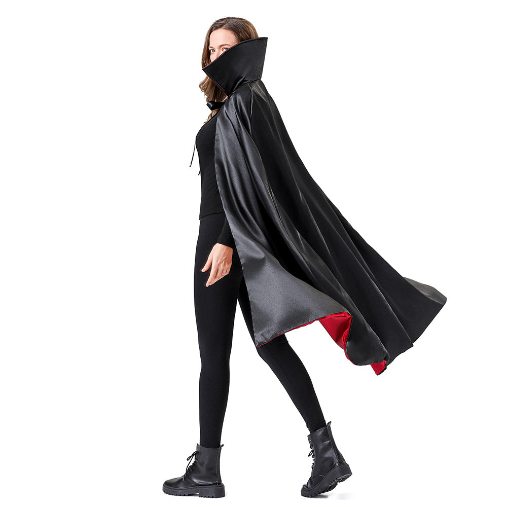 A woman modeling a long black satin-like cape with a high collar and a red lining, shown against a plain white background.