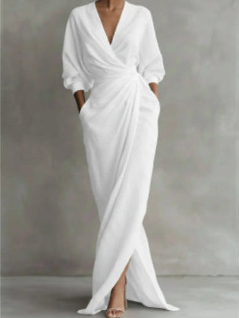 White dress with a V-neck and long sleeves on a gray background