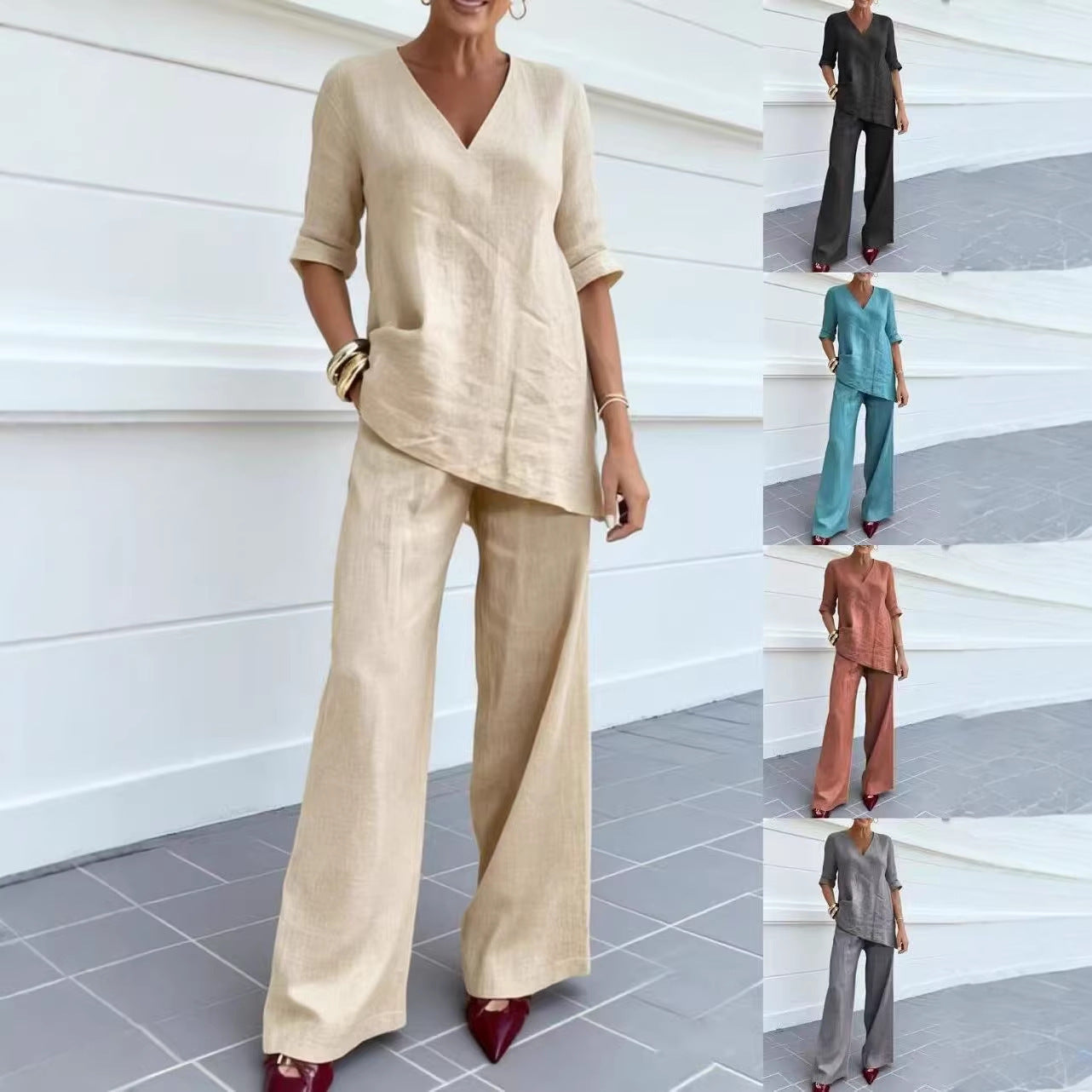 Woman wearing a beige outfit with wide-leg pants, standing against a white wall.