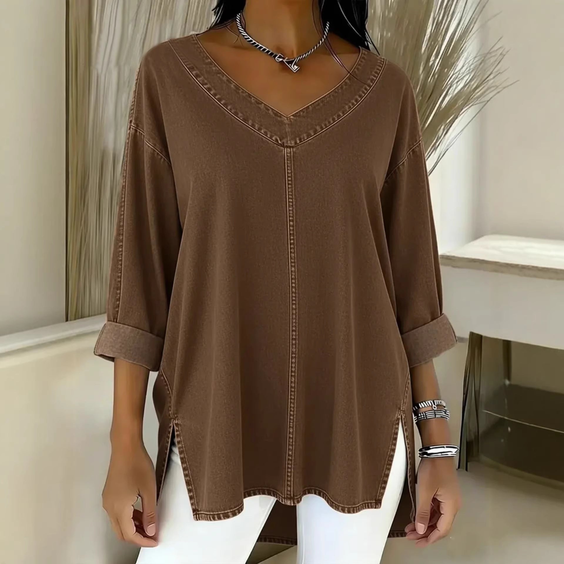 Brown long-sleeve top worn by a person in a minimal indoor setting