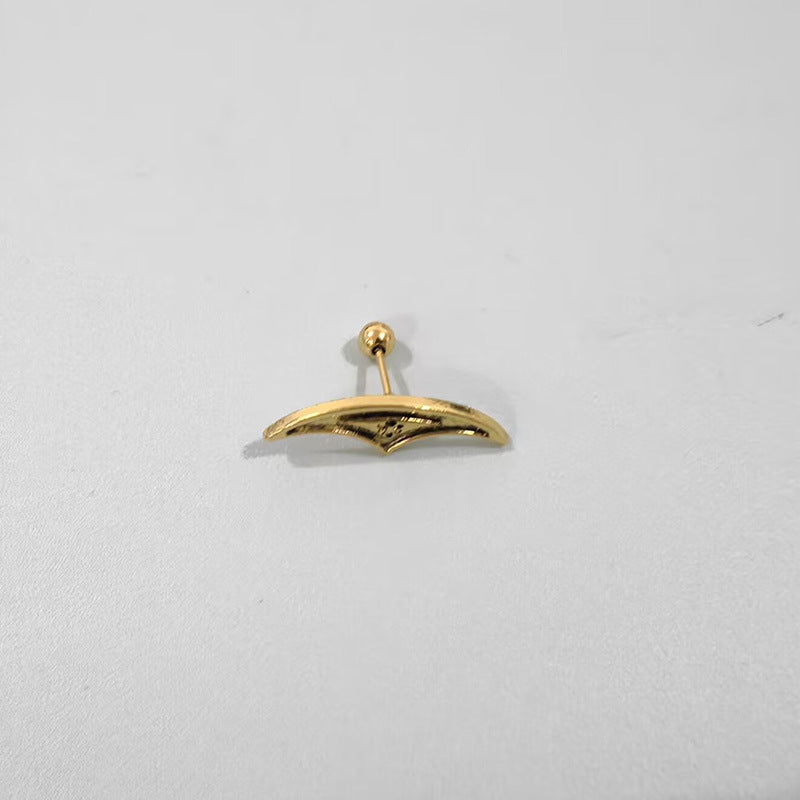 Gold earring on a light gray background
