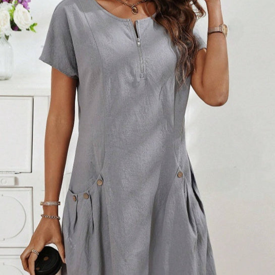 Woman wearing a gray dress with a white background