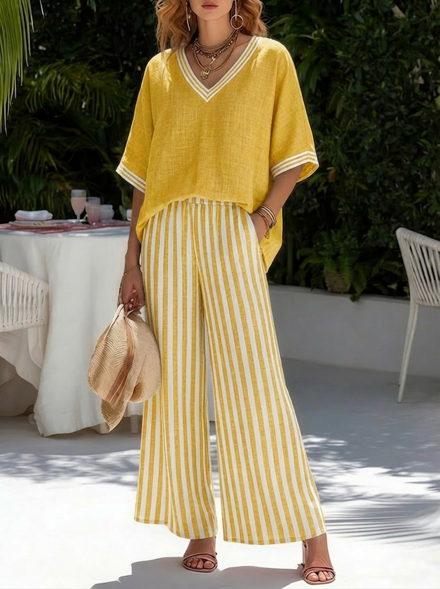Woman wearing a yellow outfit with a striped pattern in an outdoor setting.