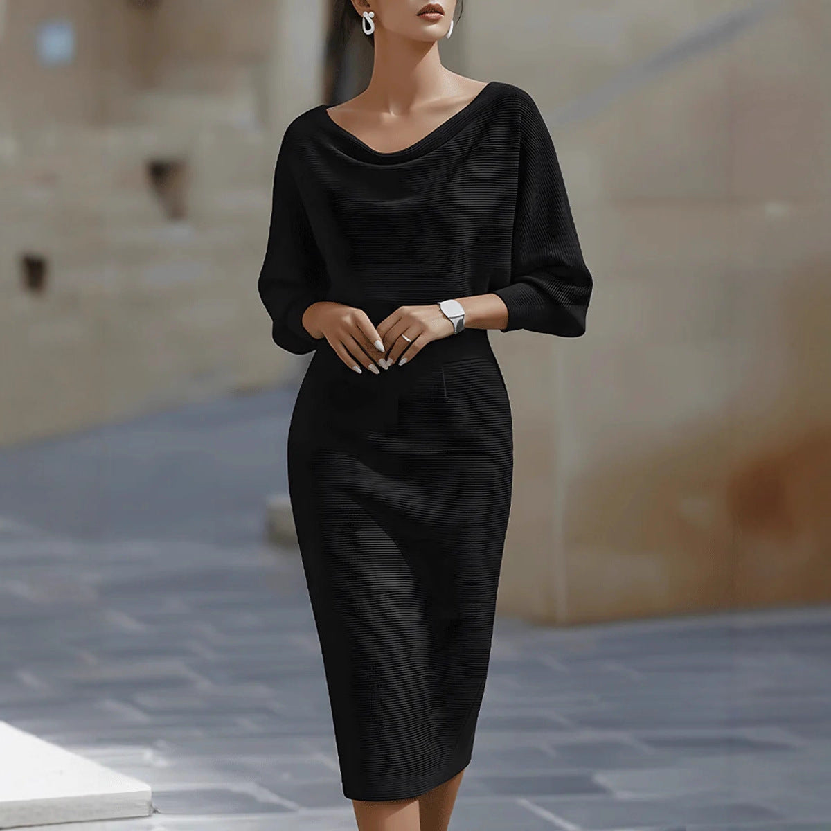 Woman wearing a black dress standing on a stone pavement.