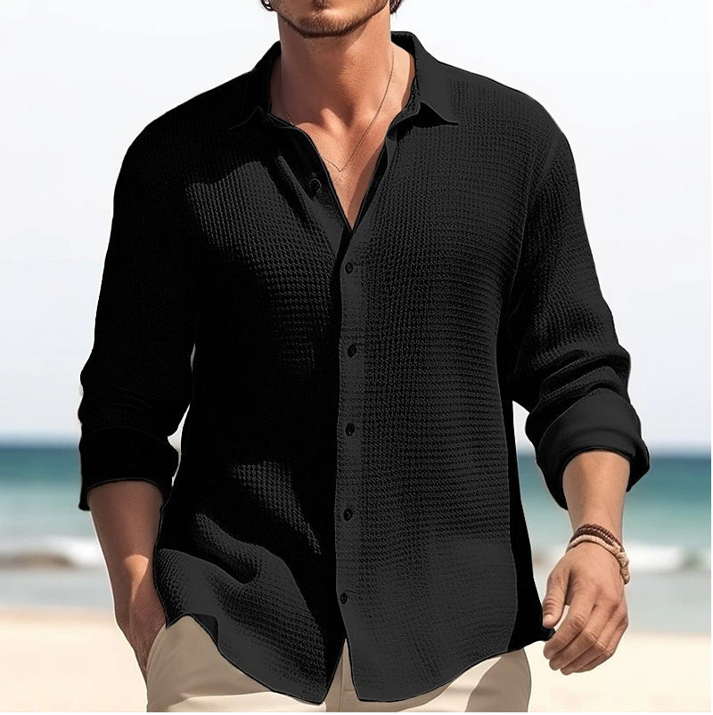 Man wearing a black textured shirt on a beach