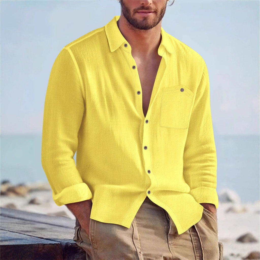Man wearing a yellow shirt with a blurred beach background