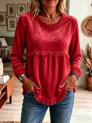 Person wearing a red top with ruffled details in a living room setting