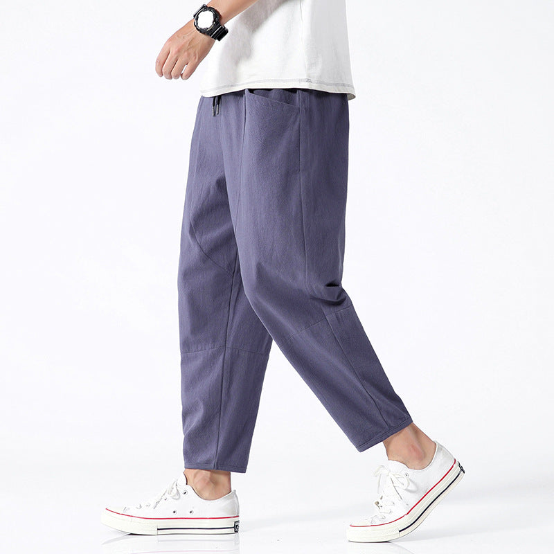 Person wearing purple pants and white sneakers on a white background
