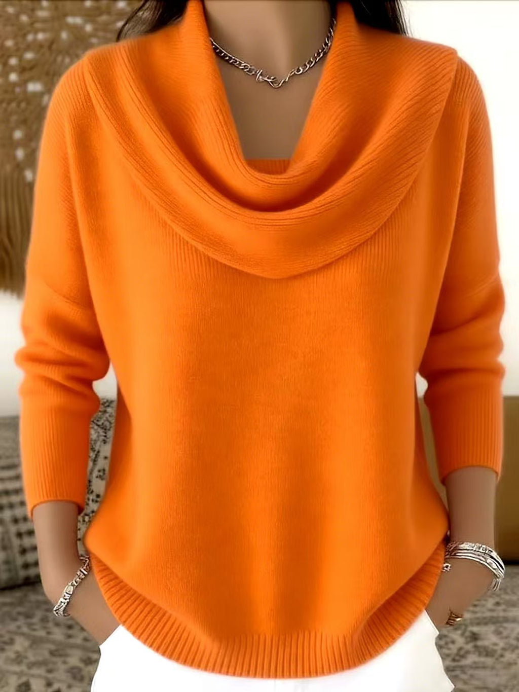 Orange sweater worn by a person with a blurred background