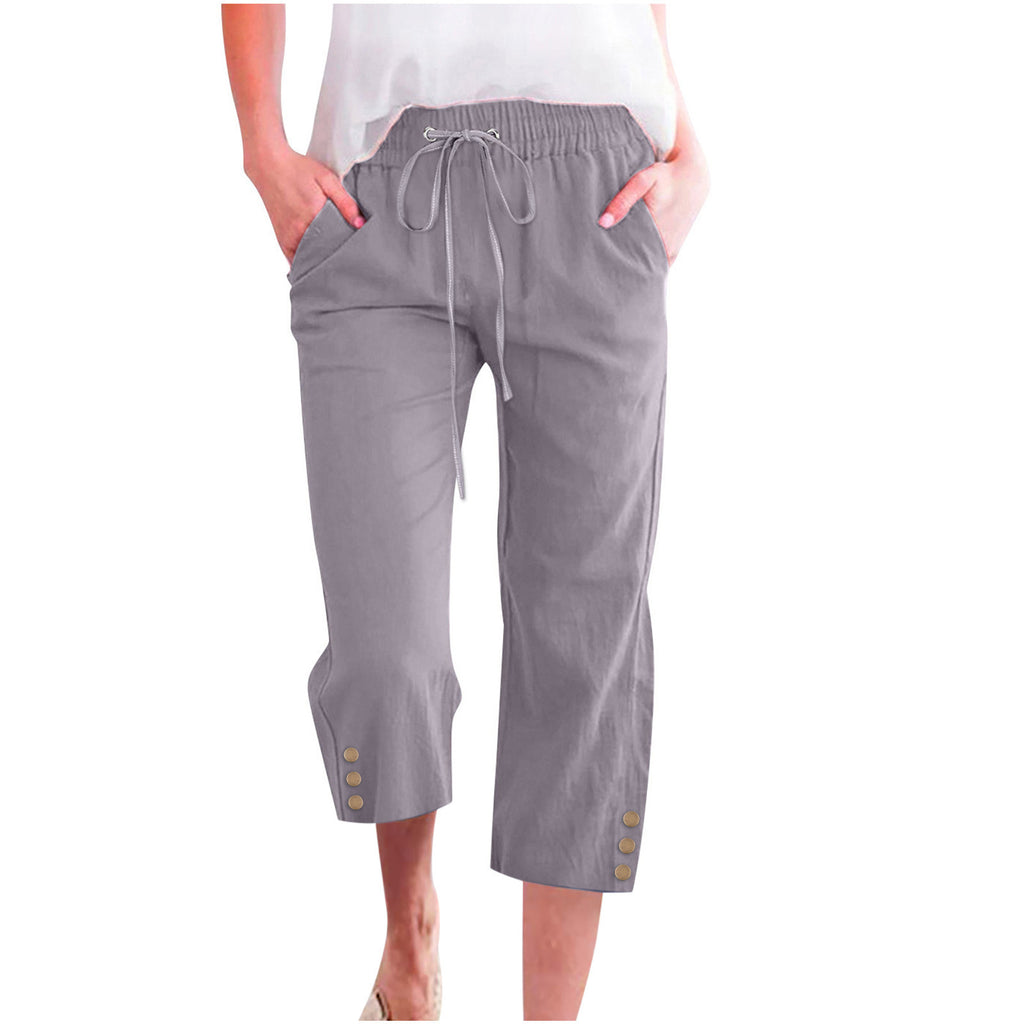 Gray capri pants with button details on a white background