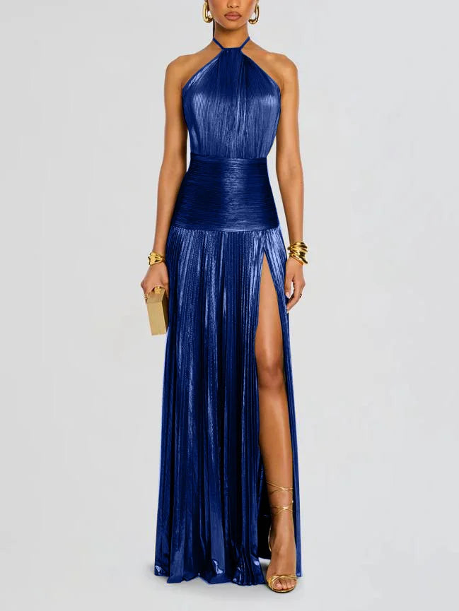 Woman wearing a blue halter neck gown with a slit on a light gray background