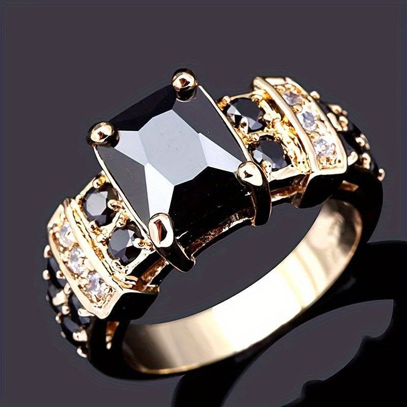 Gold ring with a large black gemstone and smaller diamonds on a dark background
