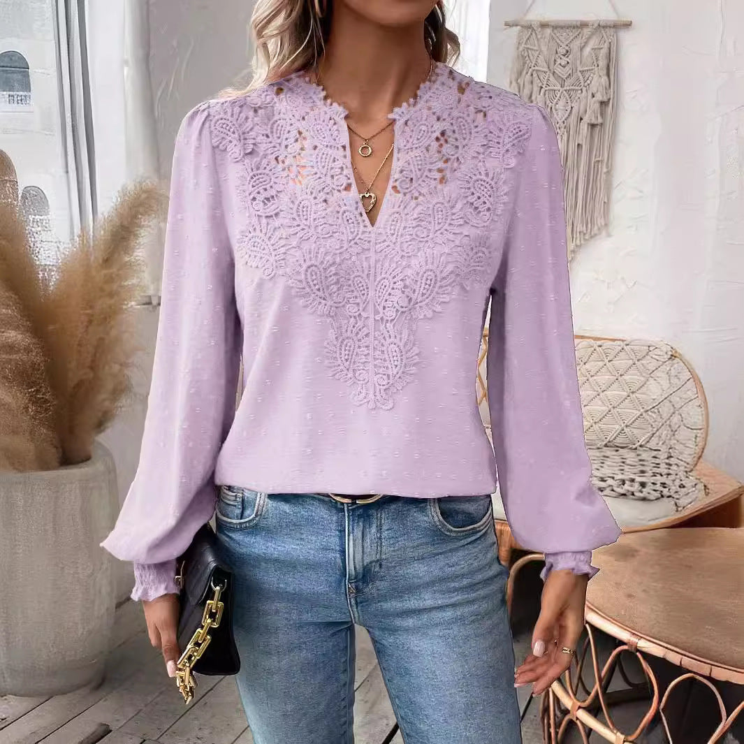 Woman wearing a purple lace blouse and blue jeans indoors.
