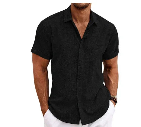 Man wearing a black short-sleeve button-up shirt on a white background