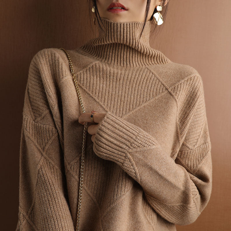 Person wearing a beige turtleneck sweater against a brown background