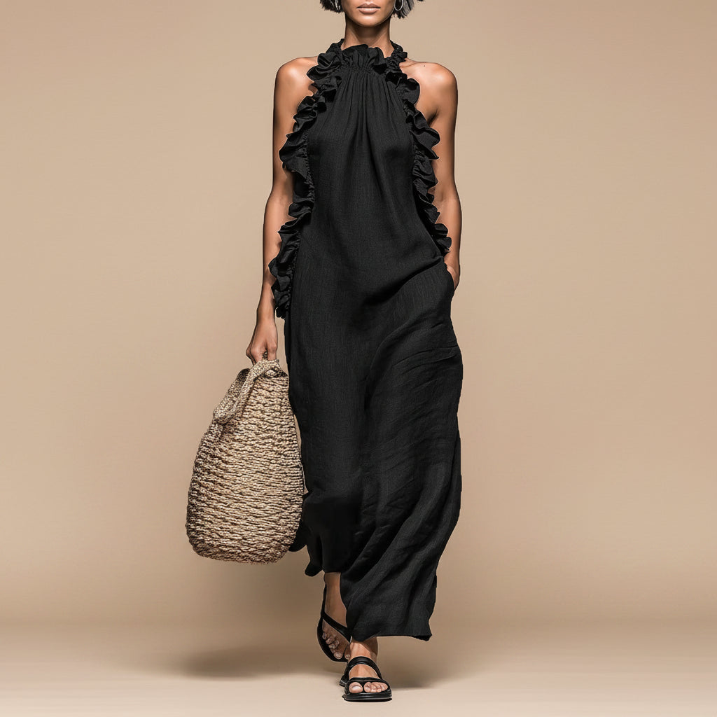 Woman wearing a black ruffled dress holding a woven bag on a white background