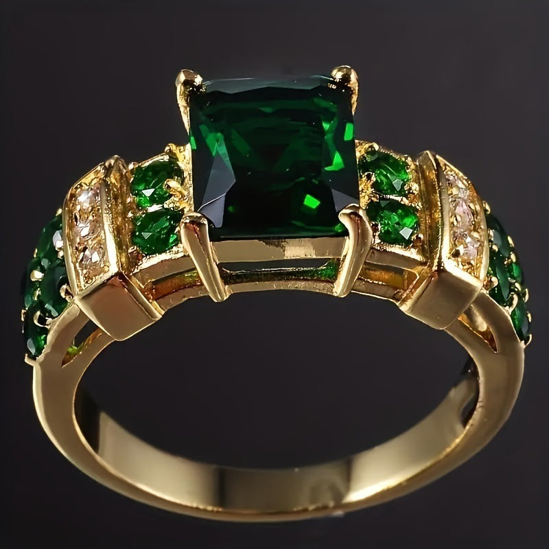 Gold ring with green gemstones on a dark background