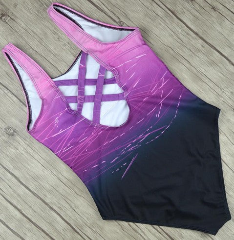 Pink and black swimsuit with white accents on a wooden floor