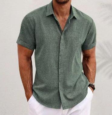 Man wearing a green short-sleeve shirt and white pants against a light gray background