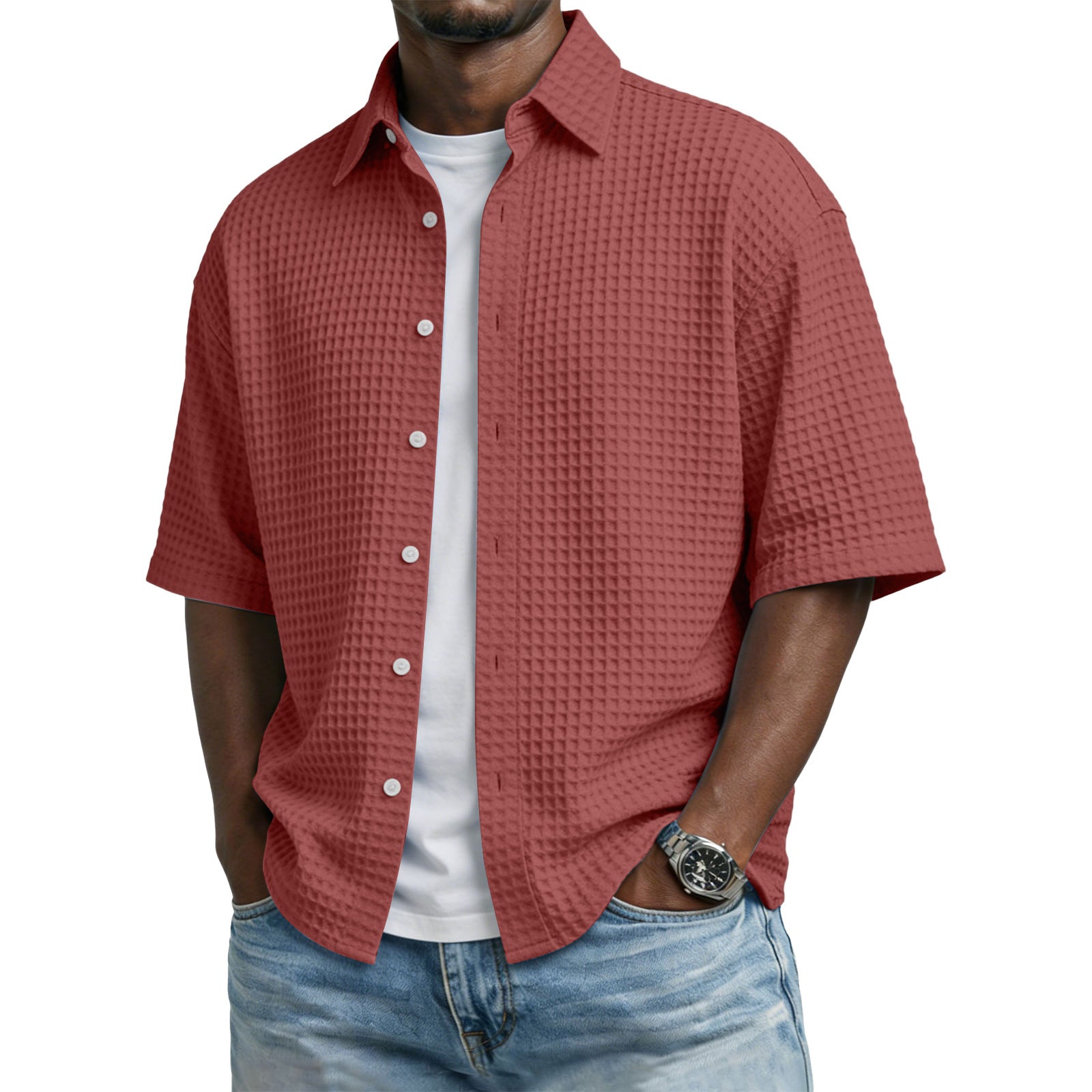 Man wearing a red textured shirt over a white t-shirt with blue jeans on a white background