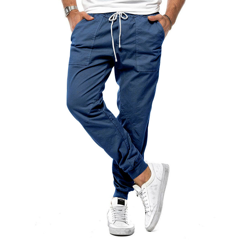 Blue jogger pants worn by a person on a white background