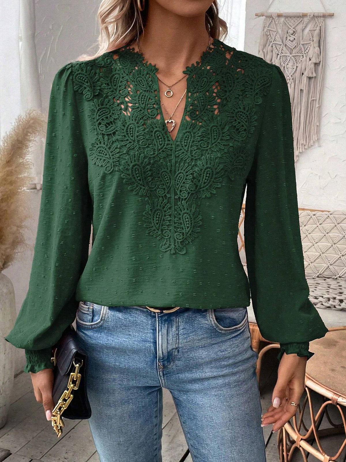 Green lace top worn by a person with a blurred background
