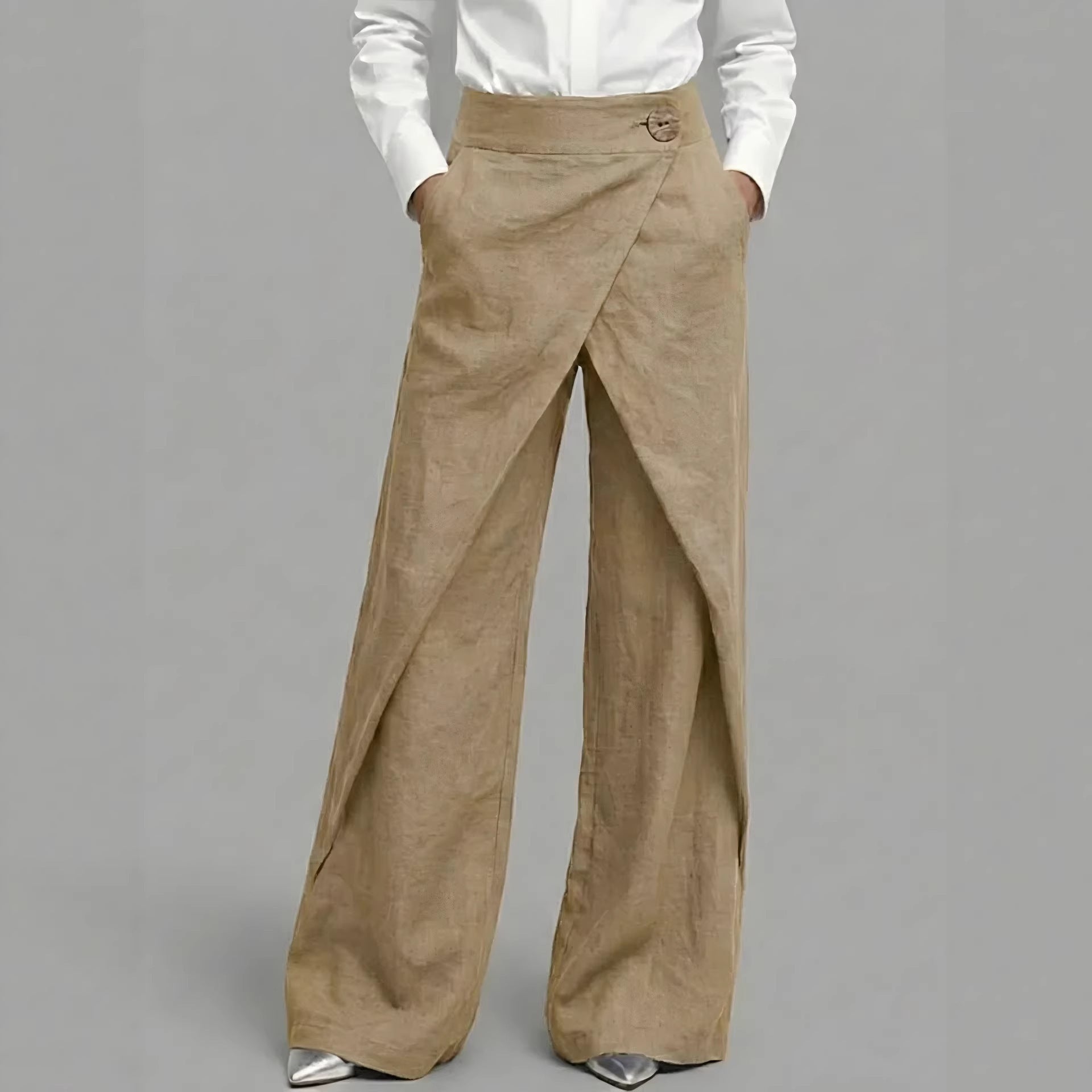 Beige wide-leg pants worn with a white shirt on a gray background