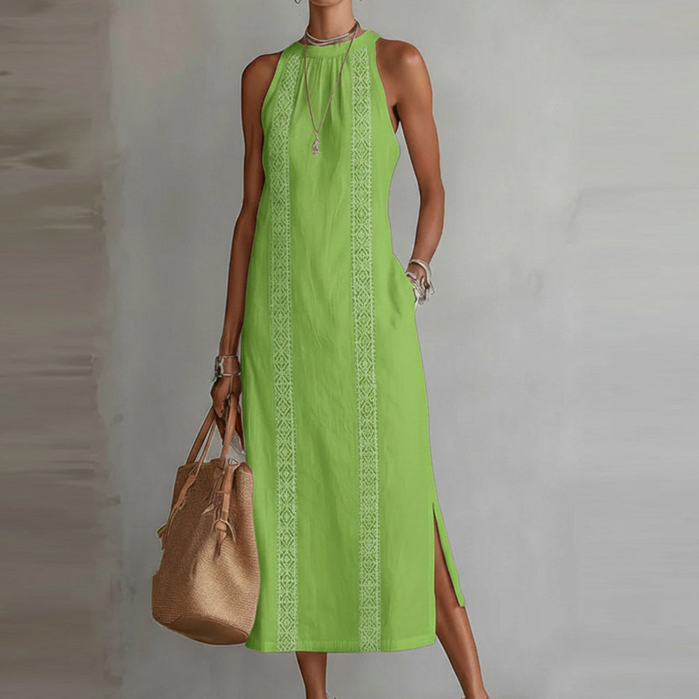 Green dress with white patterns worn by a person, holding a beige handbag against a neutral background