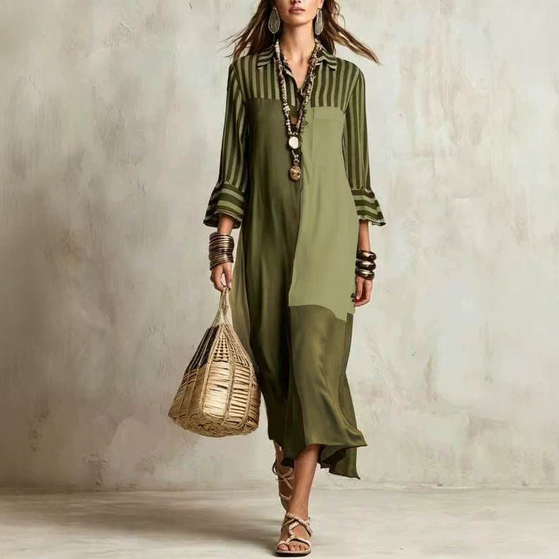 Woman wearing a green dress with striped shirt against a textured wall.