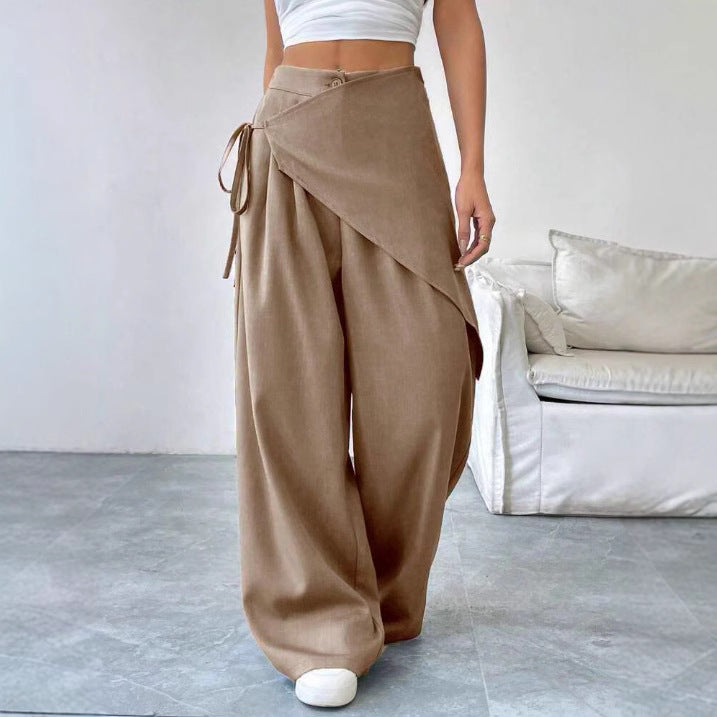 Person wearing beige wide-leg pants in a minimalistic room.