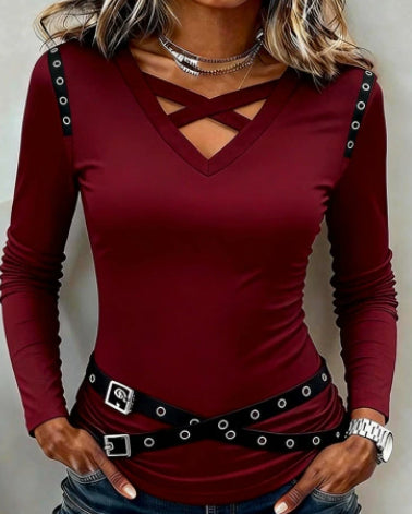 Red long-sleeve top with cut-out design and black belt on a neutral background