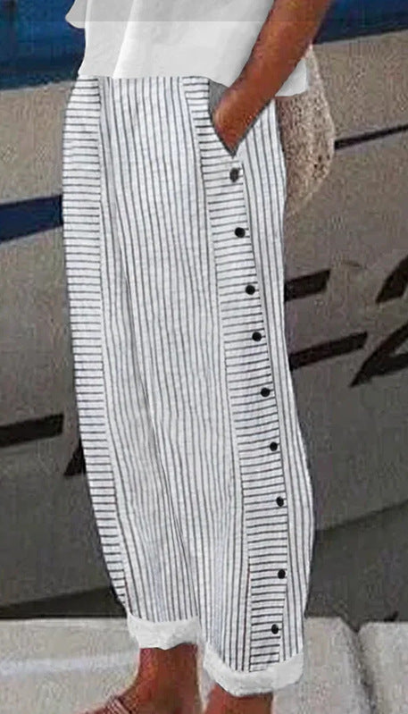 Person wearing a white top and black and white striped skirt with buttons.