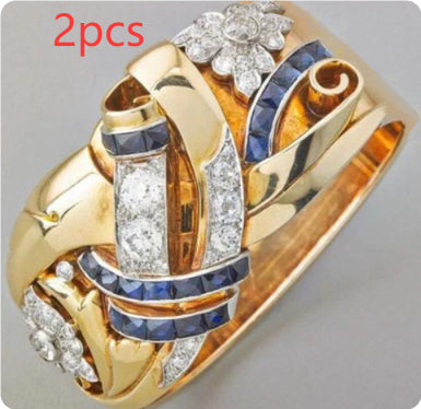 Gold ring with diamonds and sapphires on a gray background
