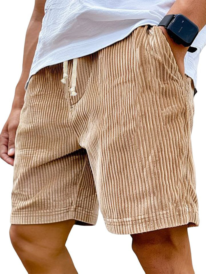 Beige corduroy shorts worn by a person on a white background