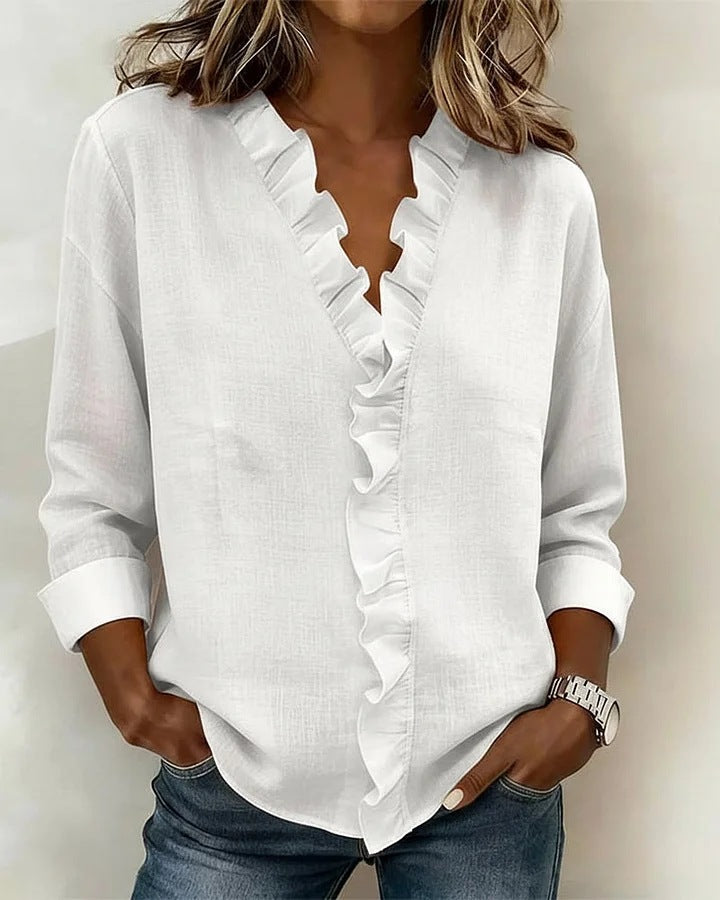 White ruffled blouse worn by a person against a neutral background