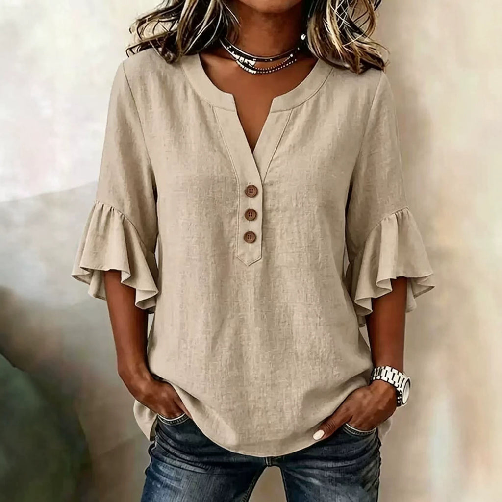 Beige blouse with ruffled sleeves worn by a person against a neutral background