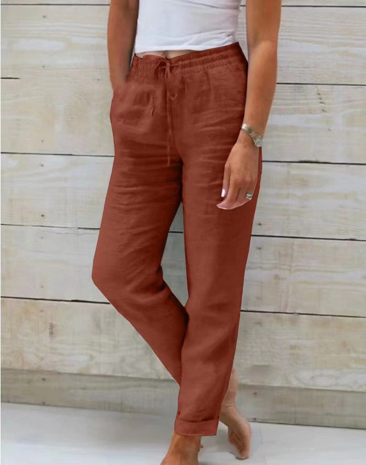 Person wearing rust-colored pants against a wooden background