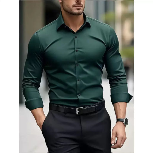 Man wearing a green dress shirt and black pants with a blurred background