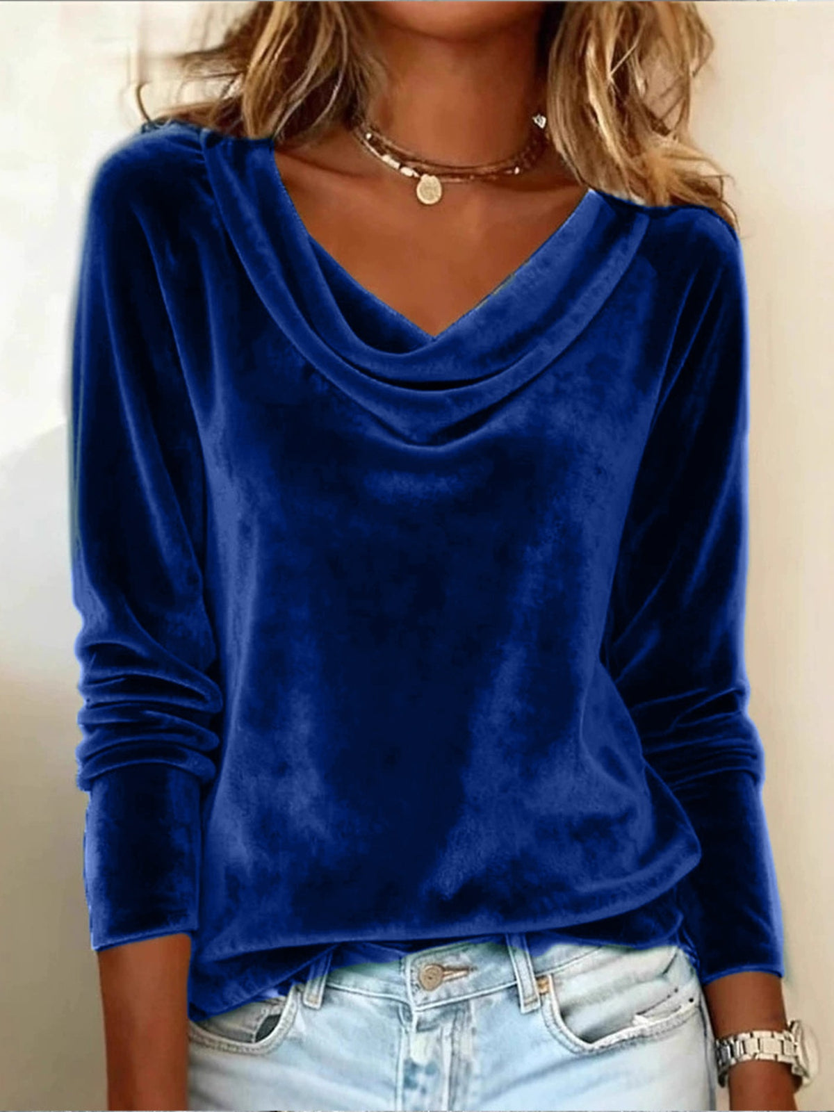 Blue velvet long-sleeve top worn by a person against a neutral background