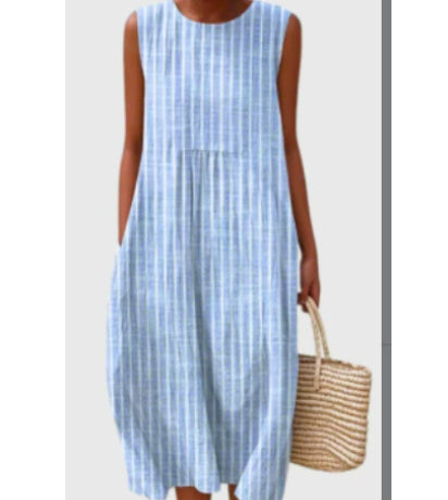 Person wearing a blue and white striped dress holding a woven bag on a plain background