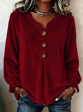 Red blouse with buttons worn by a person against a neutral background