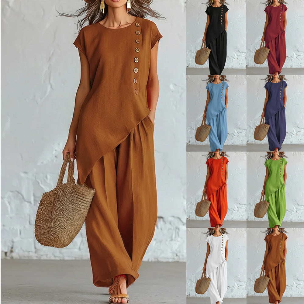Woman wearing a brown dress with button details, holding a straw bag, against a white brick wall.
