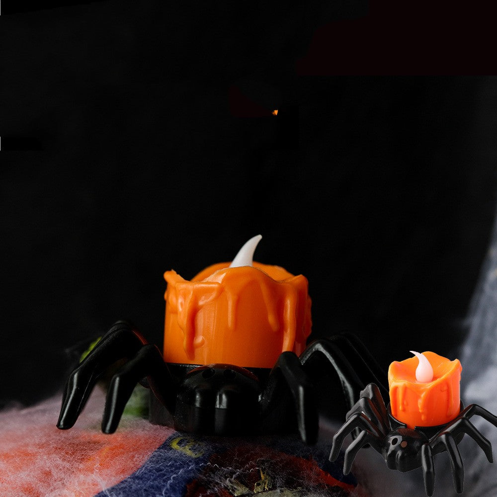 Halloween spider candles with orange candle bodies and black legs on a dark background.