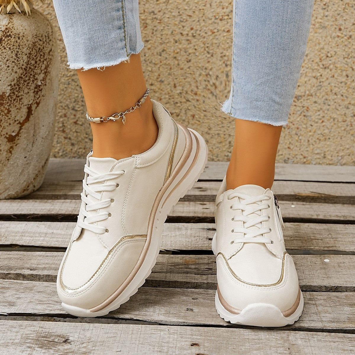 White sneakers worn on a wooden surface with a neutral background