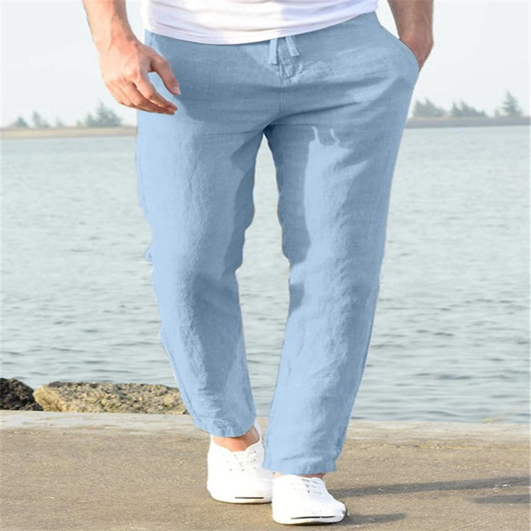Person wearing light blue pants and white shoes by a body of water.