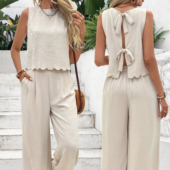 Two women wearing matching beige outfits with a white background